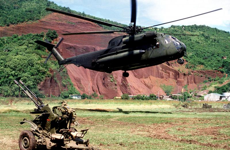 JAV „Sikorsky CH-53 Sea Stallion“ sraigtasparnis sklando prie apleisto sovietinio priešlėktuvinio ginklo ZU-23-2 per invaziją į Grenadą 1983 m.