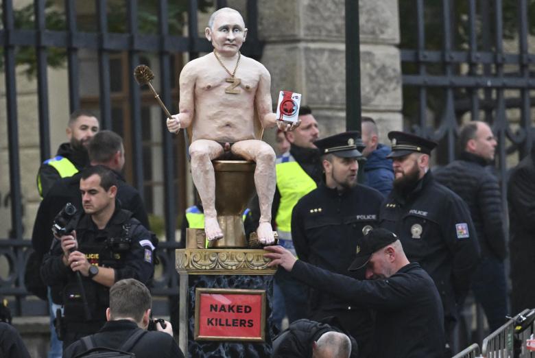 Protestuotojai prie Prahos pilies demonstruoja Rusijos prezidento Vladimiro Putino figūrą, sėdinčią ant aukso tualeto, Europos viršūnių susitikime Prahoje 2022 m. spalio 7 d.