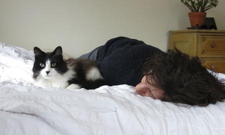 Kodėl katė miega ant žmogaus? 6 mielo įpročio priežastys. Ką daryti?