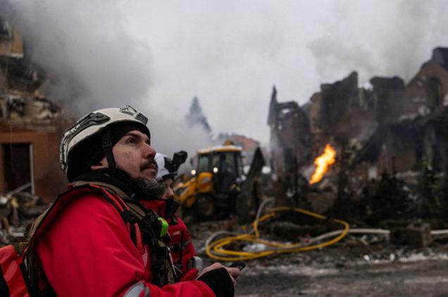 Ukrainos valstybinės ekstremalių situacijų tarnybos ugniagesiai valo griuvėsius Sofijevskajame Borshchagovke, Ukraina, po Rusijos oro smūgio gyvenamajam rajonui 2026 m. vasario 22 d.